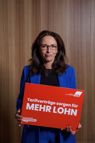 Portraitfoto von Yasmin Fahimi, die ein Plakat hält mit der Aufschrift "Tarifverträge sorgen für mehr Lohn"