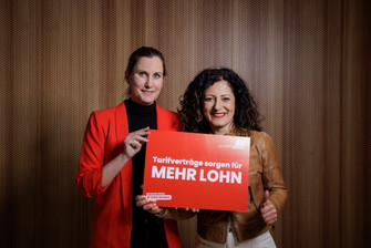 Foto von Micha Klapp und Cansel Kiziltepe mit einer Plakat mit der Aufschrift "Tarifverträge sorgen für mehr Lohn"