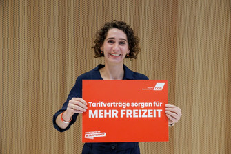 Portraitfoto von Cosima Ingenschay, die ein Plakat in der Hand hält mit der Aufschrift "Tarifverträge sorgen für mehr Freizeit". 